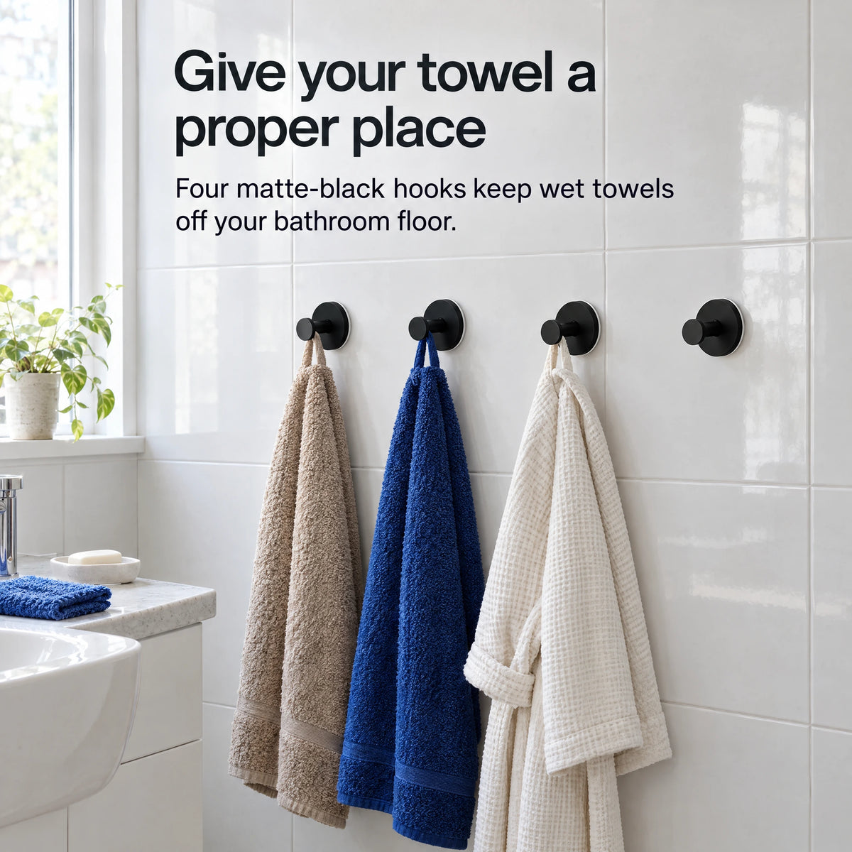 Four matte-black Twist-On Suction Hooks keep towels and a robe off the bathroom floor